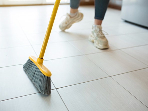 person sweeping tiled floor